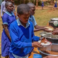 School children receiving a freshly served meal during a nutrition support program.